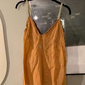 Linne/ topp - Säljer denna oanvända orangea toppen i linnematerial. Har en retro/ vintage stil med broderi på bröstet. Toppen är inspererad av 00-talet mode.  Banden är skysterbara och passar alltså de flesta beroende på hur man vill att den ska sitta!🌟