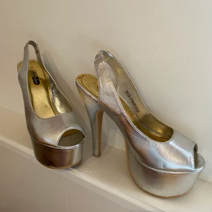 Skor med platåklack storlek 35 - Högklackade skor med platå i silver, sparsamt använda. Storlek 35 men passar mig som har storlek 36