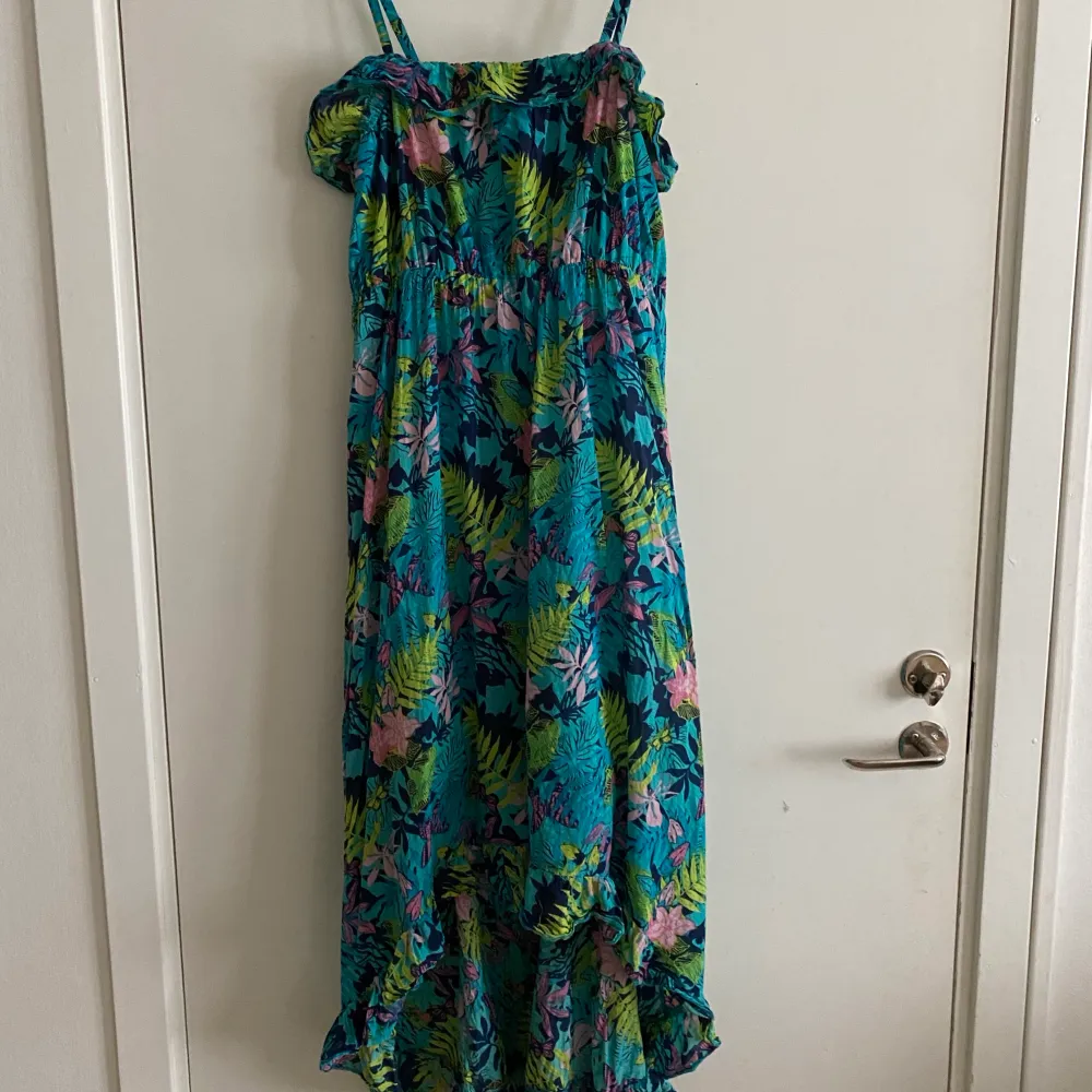 En grön/blå klänning i storlek S, men massor av blad och lite rosa blommor. Eventuell frakt betalas av köparen . Klänningar.