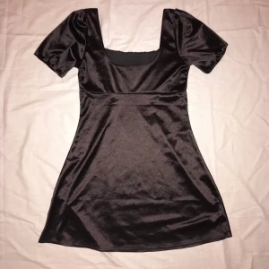 Svart klänning från H&M - Svart siden klänning med puffärmar