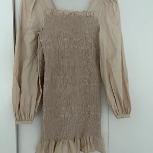 Klänning  - En beige klänning ifrån NA-KD i bra skick