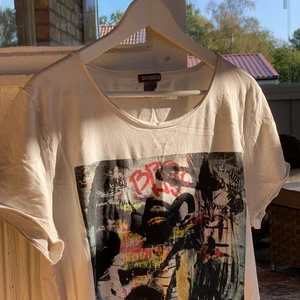 T-shirt med graffiti motiv - Graffiti motiv på framsidan. Storlek M men passar L. Knappt använt den här då den är för stor för mig. Tröjan är vit. Frakt är 45 kr. Köp nu! 😊
