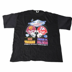 USC Trojans - Vintage Graphic T-shirt - En av våra mest unika och fetaste tröjor! Kommer vara svårt att hitta en lika autentiskt och snygg tröja som denna. Gjord för två collegefotbollslag under 03/04 säsongen. Har därför grova 00’s/90’s vibbar. Är lite baggy!