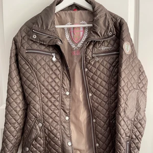 Ridjacka med mycket detaljer - Ridjacka som aldrig blivit använd, många detaljer på jackan som att det går att förminska midjan, dragkjedjor och knappar. 