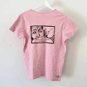 Här är en pastellrosa t-shirt med handtryckta trycket 