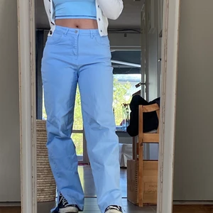 Pastellblåa NAKD jeans - Slutsålda jeans från NAKD, i den finaste pastellblåa färgen med slits på sidorna. Perfekta till sommaren! Går att ha som high waist eller dra ned om man vill det, lite långa på mig (165 cm) därför säljer jag dem! I princip nyskick för jag inte fått användning för dem ✨