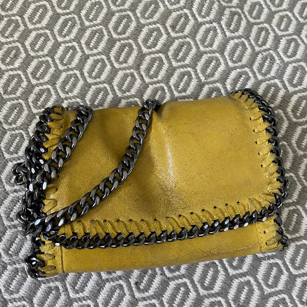Säljer min fina lilla gula väska som är köpt i Spanien! Den är i äkta läder och har en lång kedja som man kan göra kortare beroende på hur man vill ha den! Den har en dragkedja till de stora facket inuti väskan.. Väskor.