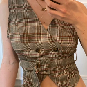 Rutig väst - Smickrande väst som går att använda på många olika sätt. 