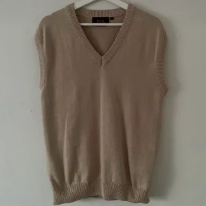 Stickad väst - Beige stickad väst i strl:M men passar allt från XS-L beroende på hur man vill att den ska sitta. Den är rätt stor i storleken!   Köparen står för fraktkostnaden😊