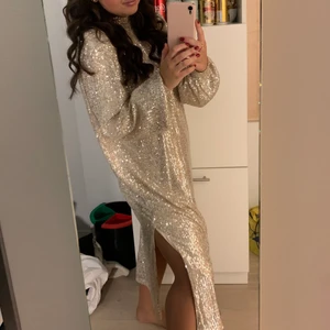 Paljettklänning från NA-KD  - Silvrig/guldig paljettklänning från NA-KD köpt förra Nyår och endast använd då🥰 det är en XS men passar mig som vanligtvis är M-S känns som en onezize 