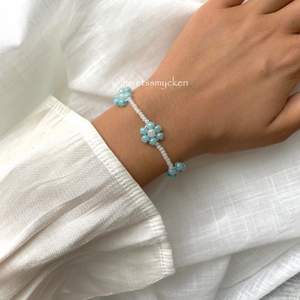 Pärlarmband av skimrande glaspärlor i ljusblå och vit nyans. Perfekt att kombinera med andra smycken! Armbandet är ihopsatt med hållbar elastisk tråd och passar de flesta handleder.
