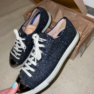Miu miu sneakers - Glittriga Miu Miu sneakers i modellen Calzature Donna i mörkblått. Använda ett fåtal gånger så i bra skick. Säljes med box, nypris ca 5000 kr. Skriv gärna vid funderingar eller om fler bilder önskas :)