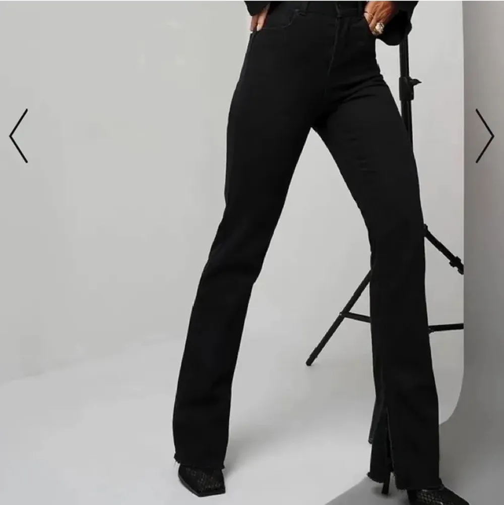 Ett par svarta jeans med slits på sidan. De är helt slutsålda på NA-KD. Dem är i storlek 36 men skulle säga att dem testar en 34:a också. Dem är aldrig använda. Jeans & Byxor.