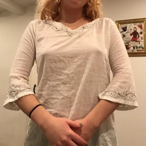 Vit blus/tröja - Knappt använd, fina detaljer sitter ganska tajt vid armarna på mig.
