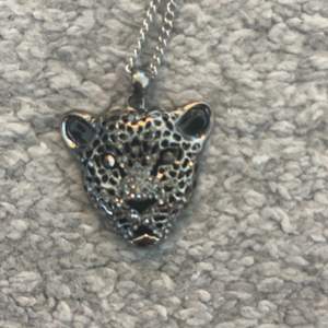Ett långt halsband med en leopard på.