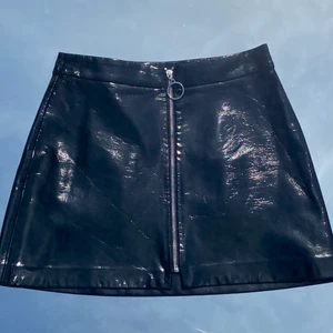 Svart lack-kjol med dragkedja - Svart lack-kjol från Zara. Sparsamt använd! Storlek S. Ser ut som repor på bilden men det är bara veck som rätar ut sig när man har den på sig. Köp flera plagg och få paketpris! 🤩