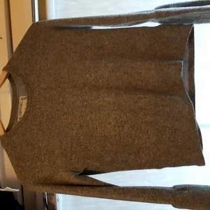 En grå tröja med litte utsvängda armar .  - En grå  tröja med litte utsvängda armar .  Är inte gör varm eller kall att ha på sig . .  