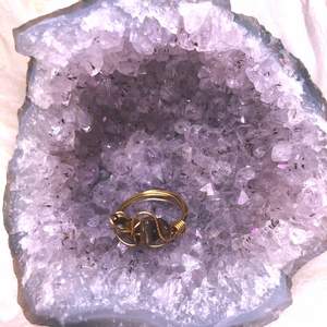 En fin och trendig kristall ring gjord av ståltråd i guld och tigeröga. är i ungefär storlek 12/6 beroende på vilken mätning man använder