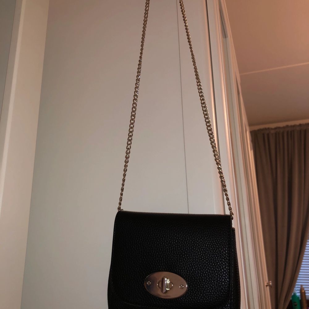 Det är en svart väska med måtten 16cm bredd ➡️, och 15 cm höjd ⬆️. Den är en väska med svart läder och har en silver kedja!💜 Man kan öppna upp sidorna så att den blir större (bild 3)!! Jätte gin väska som passar allt!💕💕. Väskor.
