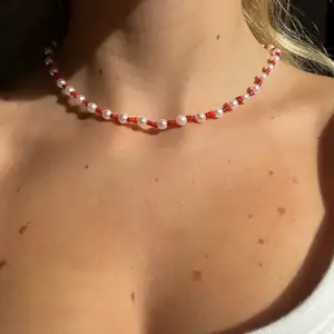 Ett super fint halsband i tre olika röda nyanser mixat med större vita pärlor ❤️ halsbandet är 40cm. Bandet är elastiskt och det ingår spänne och ringödlor så man kan justera det efter önskan ❤️