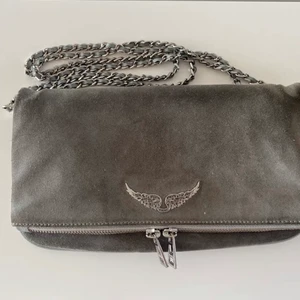 Zadig & voltaire väska - Zadig & voltaire väska i grå mocka. Köpt på Zadigs butik i Stockholm för ca 2 år sedan. Nypris 3695kr. Sparsamt använd och inga tydliga defekter. Dustbag ingår! 