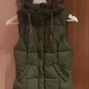 HM LOGG  - Grön vinter väst från logg i polyester och huva med stängning i fickorna