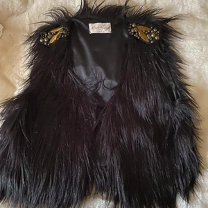 Svart väst - Fejkpäls med guld detaljer på axlarna