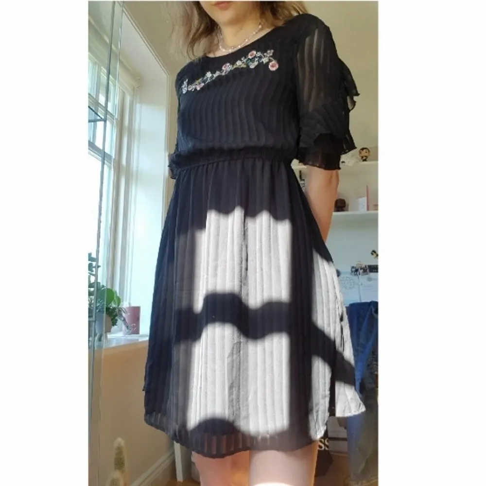 Säljer denna svarta gulliga klänning från New Look. Den har lite blommiga detaljer där fram och lite volanger på ärmarna. Den är bara använd en gång och går ner till låren på mig som är 173🥰. Klänningar.