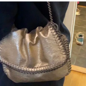 Stella McCartney liknande väska - Säljer denna så fina guldglittriga väskan med kedja från Gina tricot, väldigt sparsamt använd så superbra skick💖