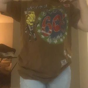 T-shirt med detalj - Jätte cool brun tröja med pärlor och tryck. Så fin och har fin passform. Passar dig som gillar stora baggy t-shirts.