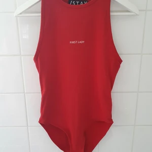 Body - Röd body med texten First Lady. Normal i storlek. Endast testad.