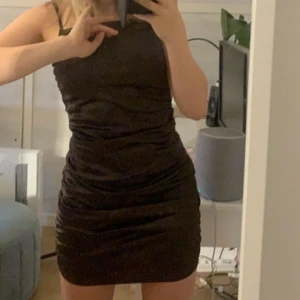 Mörkbrun klänning - Säljer min favoritklänning så den tyvärr inte kommer till använding. Nyskick i strl S, sitter superfint på mig som är xs/s men skulle även passa på en M då den är väldigt stretchig. Går att justera längden eftersom den är veckad i sidorna. Framhäver dina former jättebra. Den säljs ej längre, varken i butik eller på nätet!