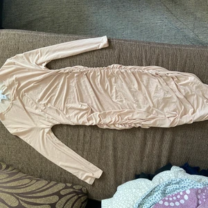 Klänning från Nelly  - Aldrig använd, jätte fin klänning från Nelly, nude/beige färgad