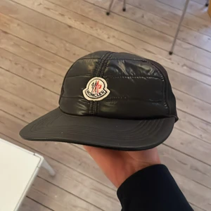 Moncler keps i mycket bra skick! - Äkta moncler keps knappt använde som är i mycket bra skick Ny pris på den är 2500kr säljer den för 1500kr då jag inte använder den.