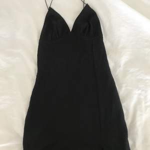 Stretchig svart klänning med öppen rygg och urringning