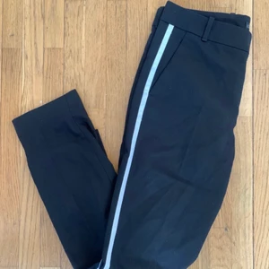 Zara Woman, Kostymbyxor, Strl: S/36 - Svarta kostymbyxor från Zara Woman. Storlek S.  Kan säkert passa XS och M också. Vilket ungefär är som storlek 36/38.  Med pressveck och vit rand på sidorna. 