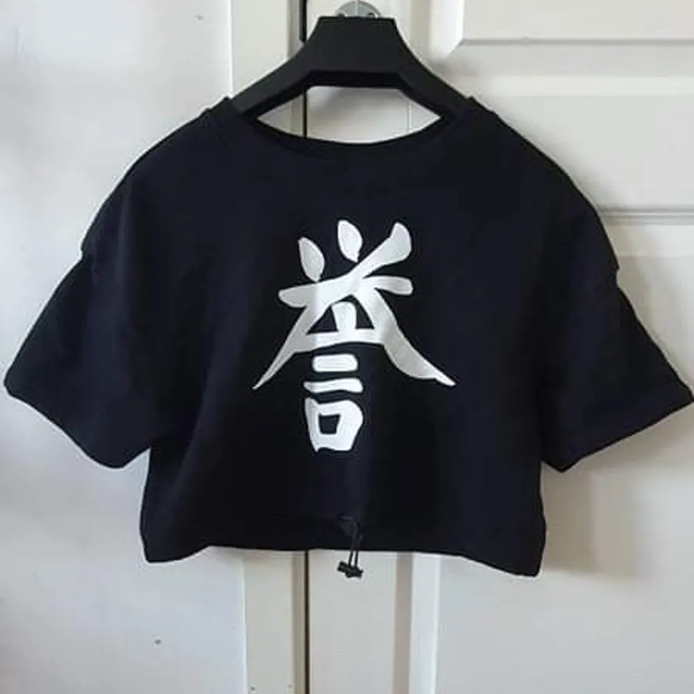 Svart t-shirt med vitt kinesiskt märke justerbar i midjan storlek XS/S. T-shirts.