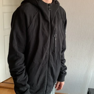 Sail racing zip hoodie black - XL barnstorlek, använd 1 gång, köpt från sailracing.com men den var för stor. Den sitter bra som oversize men även snyggt som vanlig hoodie. En månad gammal. Fungerar till både jeans och mjukisbyxor. 
