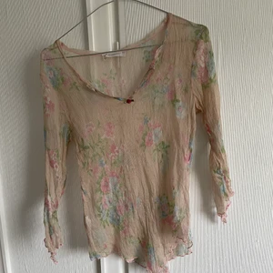 Vacker genomskinlig blus - Vacker genomskinlig blus, små plisseringar med blommor. Från etti elisa cavaletti. Små slitningar i armhålorna, hör av er för mer bilder!