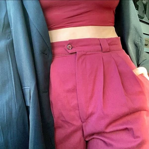 Vinröda kostymbyxor  - Vinröda plisserade kostymbyxor med långa ben i oversize stuk. Midja: 76 cm, Innerbensmått: 79 cm, längd: 111 cm