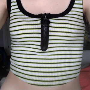 Randigt linne - linne med gröna, vita och svarta ränder, och dragkedja 