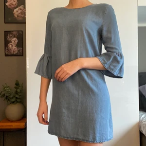 Jeansklänning - Klänningen är inte gjort av jeanstyg utan av ”vanligt tyg”, vilket gör den väldigt bekväm. Ser däremot exakt ut som jeans. Har volangärmar. 