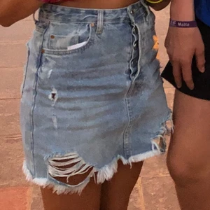 Jeanskjol - Jeanskjol med slitningar perfekt till sommaren, köpt för ca 2 år sen men i bra skick. Från stradivarius storlek 36. Pris 80kr+frakt. Kom privat för mer bilder/frågor