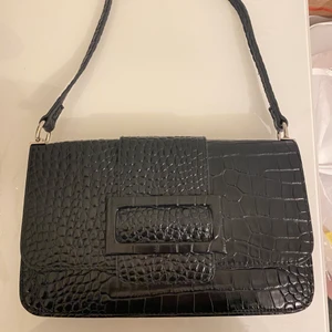 svart väska - Svarr väska med mönster ifrån nelly, knappt använd. Nypris 399 kr, säljer pågrund av att jag har liknande andra väskor💓 pris kan diskuteras. Har ett stort fack samt två mindre där ena har dragkedja!