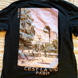 Svart T-shirt med tryck på ryggen - Helsvart t-shirt med tryck på ryggen, storlek S