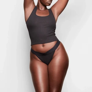 Skims Cotton Rib Tank (S) - En klasisskt basplagg som är perfekt att sova i, ha hemma eller till vardags. Så bekvämt material och perfekt passform. I färgen soot, det vill säga svart. Helt oanvänt!