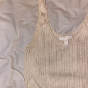 Linne - Sött ribbat linne från HM i en fin krämvit färg! Tröjan är använd ett fåtal gånger! Är i storlek S