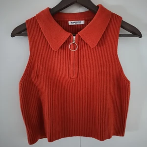 Roströd croptop - En roströd/orange stickad croptop från Glamorous i storlek 44. Tröjan är väldigt stretchig och skulle säga att den passar fler storlekar. Jag bär vanligtvis strl M och den sitter lite oversized på mig. Tröjan är i nyskick, endast använd en handful gånger! 