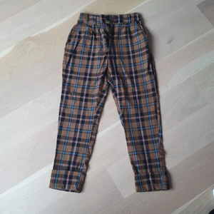 Snygga rutiga byxor  - Snygga byxor från bershka använda max 2 gånger! Sitter jättefint över rumpan. Högre modell med fickor. Brun/blå/röd rutiga. Resår baktill i midjan.