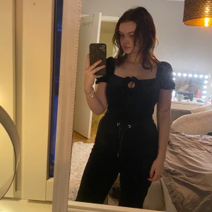 Svart body med snörning - Säljer en gullig svart body med snörning i satin. Från glamorous i storlek XS.